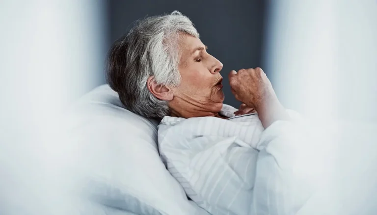 A dirty CPAP may cause a CPAP cough. High-angle shot of a sickly senior woman coughing while lying in bed.